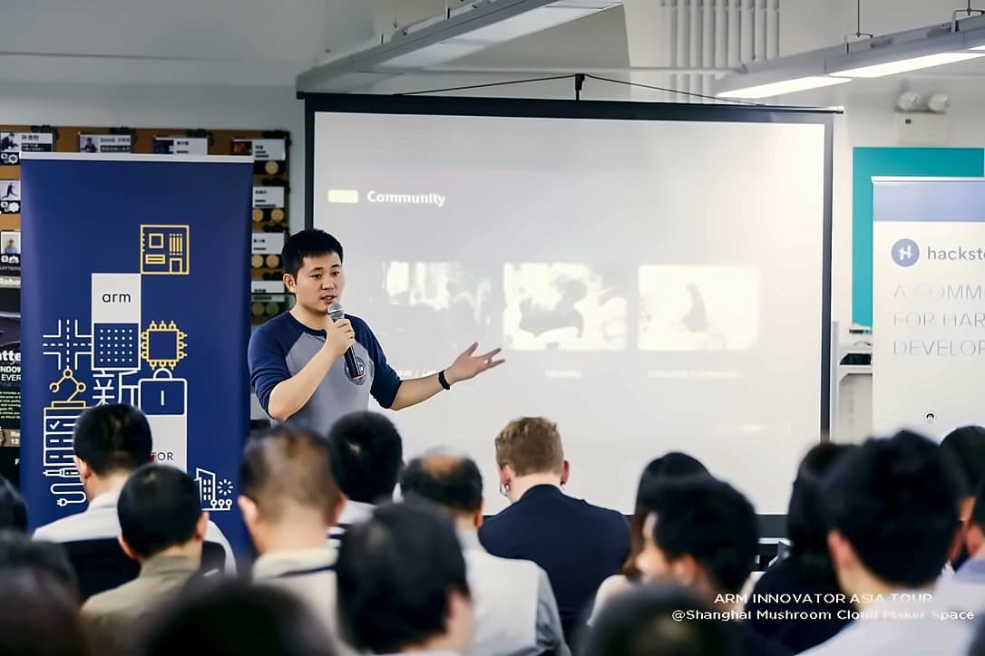 A speaker presenting a slide headed Community to a full room at the Shanghai Mushroom Cloud Maker Space