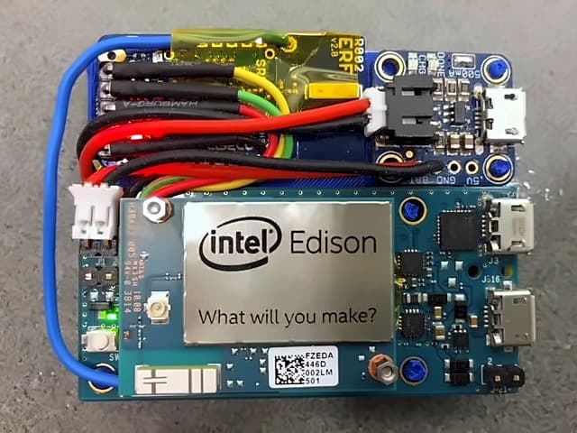 An Edison rig wired to a radio board and battery with coloured jumper leads, assembled by hand