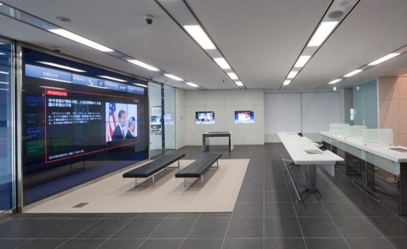 A Citibank branch interior with the touch wall running along the wall as a row of large interactive screens