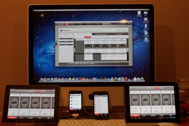 The TBC application running across a desktop monitor, a tablet and a phone on a desk